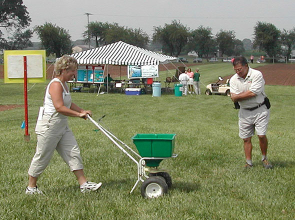 Woman using a commercial-grade, push-type spreader.