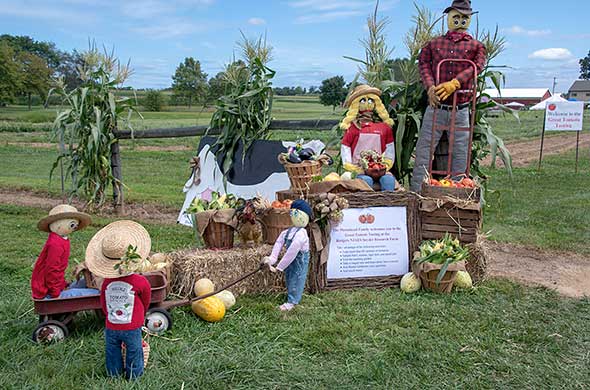 Autumn display featuring dummys dressed like a farm family, with melons for heads.
